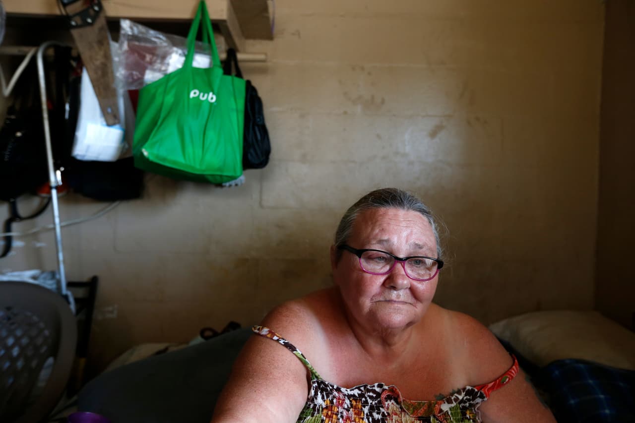 Pattie Deeley tiene asma y otros padecimientos de salud que la mantienen conectada a una máquina de oxígeno. En la imagen, aguarda a que la luz regrese en su apartamento de Immokalee, Fla. Unable to cook after the storm, Deeley said she had to spend extra money buying meals after Irma.