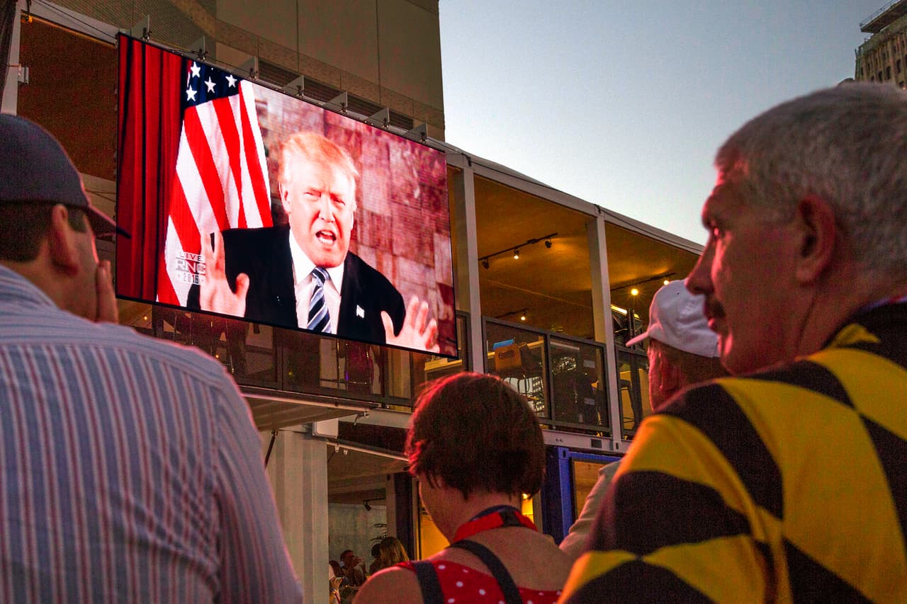 MARTES 19 DE JULIO. 9:06 PM. Desde fuera del auditorio, en el espacio abierto del Quicken Loans Arena, muchos delegados vieron el video donde el recién nombrado candidato republicano Donald Trump se dirigía a los asistentes para agradecer la nominación.
