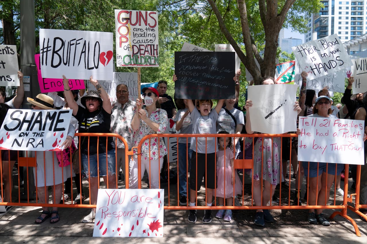 Manifestantes afuera de la convención de la NRA. Uno de ellos, Horacio Izaguirre, de 18 años, estudiante de último año de secundaria en Deer Park, un suburbio de Houston, llevaba un cartel que tenía una palabrota junto al nombre de Abbott.
<br>“Esas pobres almas inocentes no se merecían eso”, dijo, 
<a href="https://www.univision.com/noticias/estados-unidos/cinco-primos-murieron-tiroteo-texas-primaria-robb-uvalde-texas" target="_blank">refiriéndose a los niños que murieron en la primaria de Uvalde</a>. “Tengo un hermano, tengo primos. Quiero que estén a salvo”.
