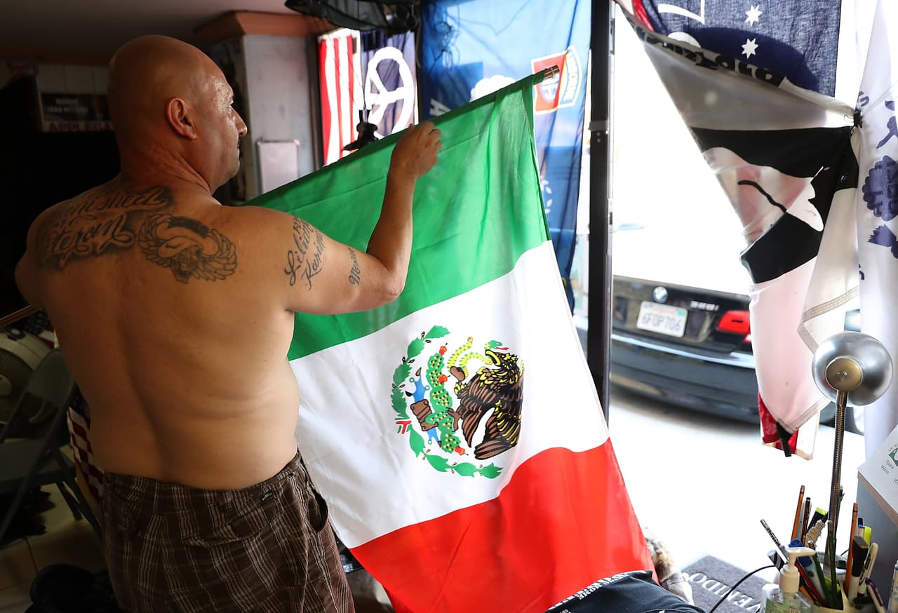TIJUANA, MEXICO - JULY 04: Deported U.S. Army veteran Hector Barajas rolls up a Mexican flag at the Deported Veterans Support House on July 4, 2017 in Tijuana, Mexico. The Deported Veterans Support House, also known as "The Bunker" was founded by deported U.S. Army veteran Hector Barajas to support deported veterans by offering food, shelter, clothing as well as advocating for political legislation that would prohibit future deportations of veterans. There are an estimated 11,000 non-citizens serving in the U.S. military and most will be naturalized during or following their service. Those who leave the military early or who are convicted of a crime after serving can be deported. (Photo by Justin Sullivan/Getty Images)