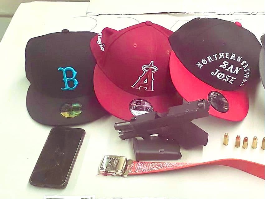 Esta pistola cargada fue decomisada junto con dos presuntos pandilleros norteños en un vehículo. Los pandilleros norteños se caracterizan por usar accesorios rojos, como se aprecia en la imagen.
<br>