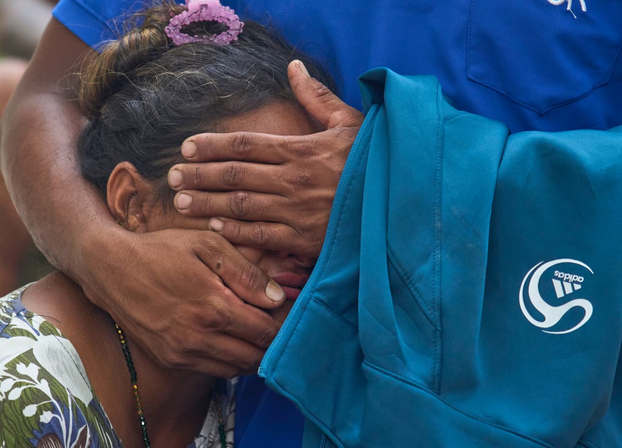 Una mujer consuela a un familiar mientras esperan noticias de sus parientes desaparecidos tras las inundaciones repentinas a lo largo del río Trishuli.