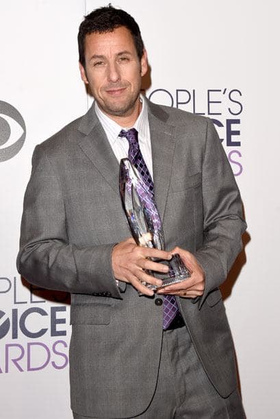 Adam Sandler entró de "pisa y corre" a la sala de prensa a presumir su trofeo.