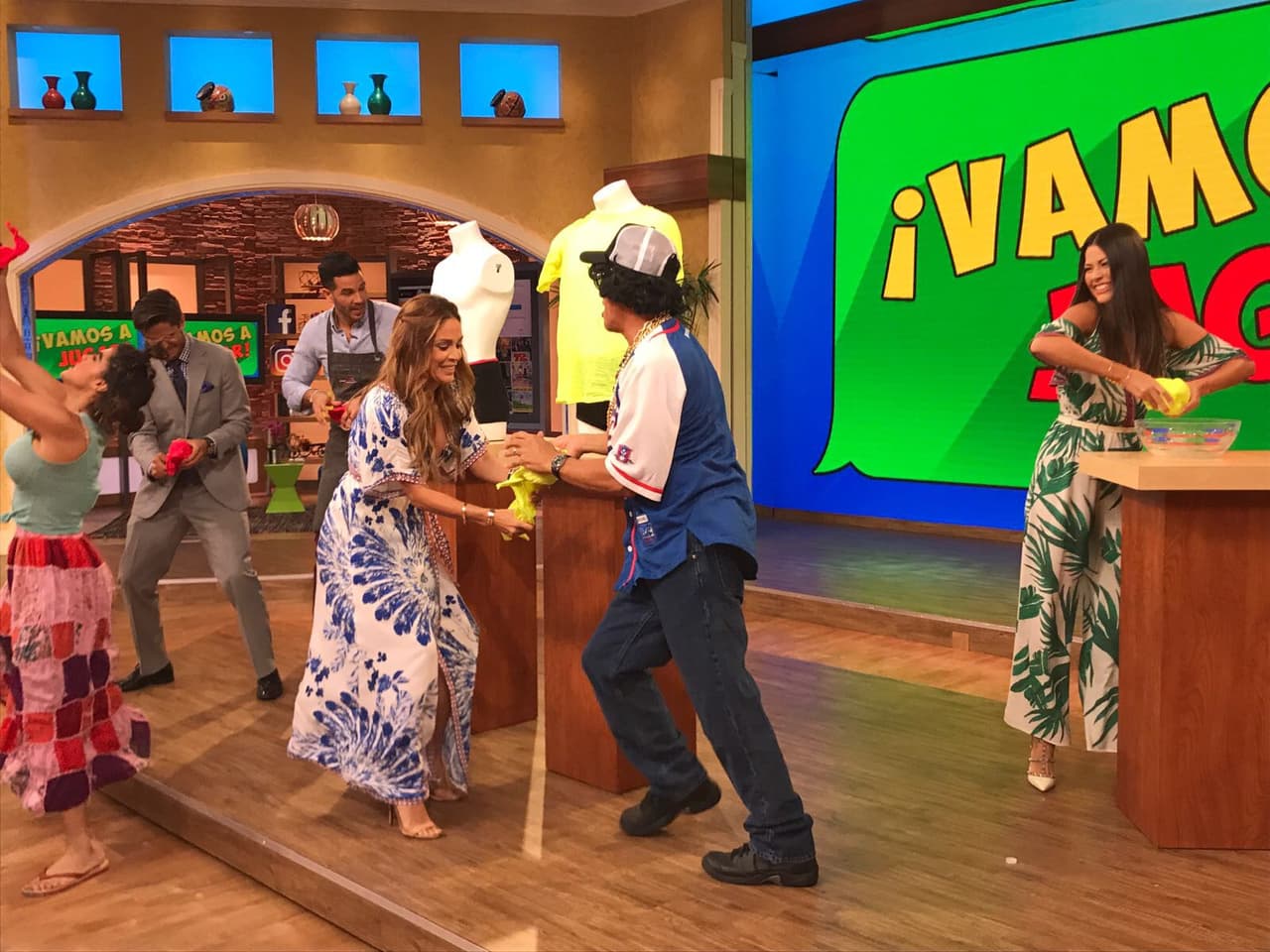 Con la ayuda de Johnny C, Karla intentaba desdoblar la camiseta.