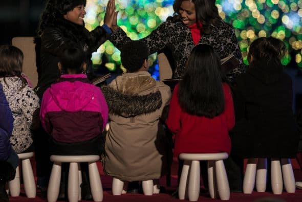 Aquí vemos a Michelle Obama saludando a un grupo de niños apostados a unos metros del árbol navideño.