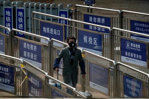 Un pasajero lleva puesta una mascarilla mientras camina hacia el metro de Pekín.