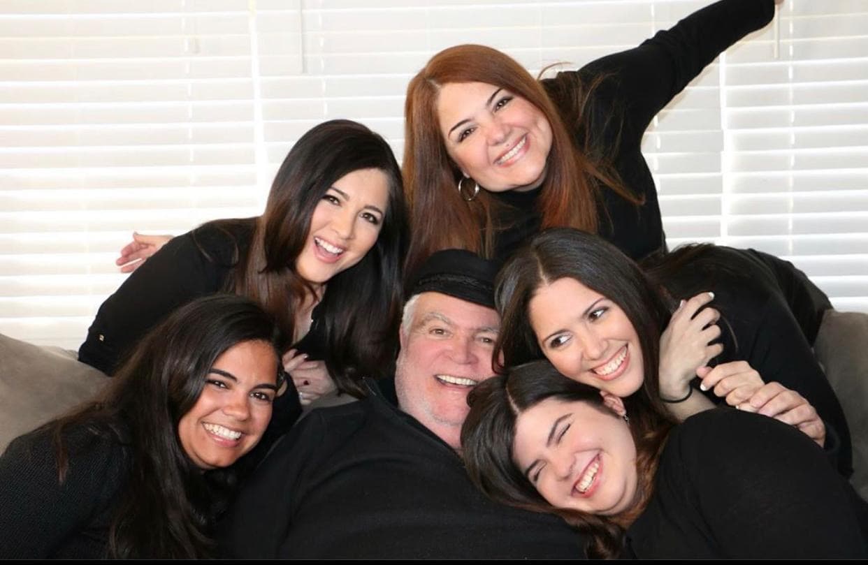 Don Carlos es el orgulloso padre de nuestra mujer ancla 
<a href="https://www.univision.com/local/philadelphia-wuvp/ilia-garcia">Ilia García</a>. “Es el papá más cariñoso. Es nuestro fan #1. Papi es el que en cada oportunidad nos recuerda que nos ama y lo hace con sus acciones y también con sus palabras”, compartió la también productora ejecutiva de Noticias Univision 65. “Me siento bendecida de tener el mejor padre, quien además siempre busca hacernos reír con sus ocurrencias”, agregó Ilia. 
<br>
<br>A juzgar por las sonrisas de las hermanas García… algo les habrá dicho don Carlos. 
<br>