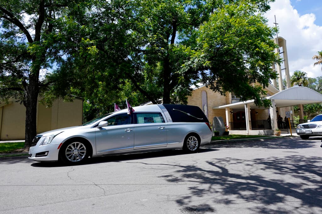 El coche fúnebre se aleja de la Iglesia Católica del Sagrado Corazón después de los servicios funerarios de José Flores Jr.