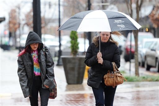 Bailey Watson y su madre, Shantel Watson, caminan bajo la lluvia en Evansville.