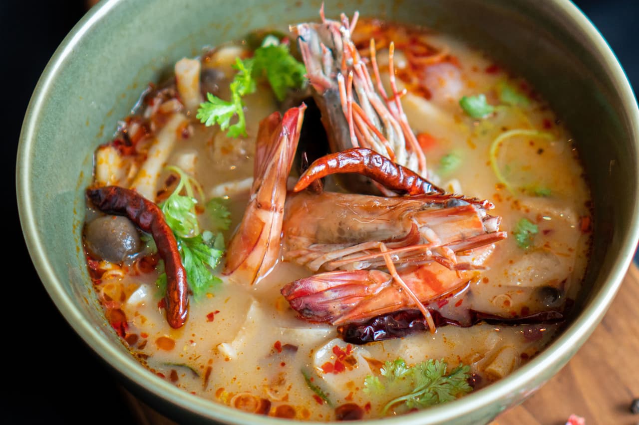 <b>Tom yum goong</b>
<br>
<br>
<b>Origen: Tailandia</b>
<br>
<br>El magnífico caldo de esta sopa es dulce, agrio, picante y salado, el complemento ideal para los camarones.
<br>
<br>Sus ingredientes aromáticos incluyen galanga (parecido al jengibre), hierba de limón, chiles rojos y hojas de lima.
<br>
<br>De las muchas variedades de la sopa tom yum de Tailandia, Tom yum goong es la única que incluye grandes camarones.
<br>