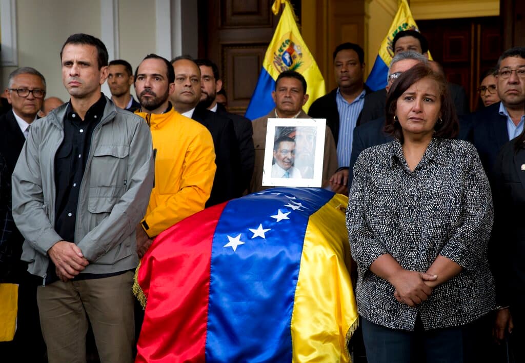 La legisladora Dinorah Figuera, a la derecha, junto al ataúd cubierto con una bandera que contiene los restos del activista opositor Fernando Albán durante una ceremonia solemne en la sede de la Asamblea Nacional en Caracas, Venezuela, el 9 de octubre de 2018.