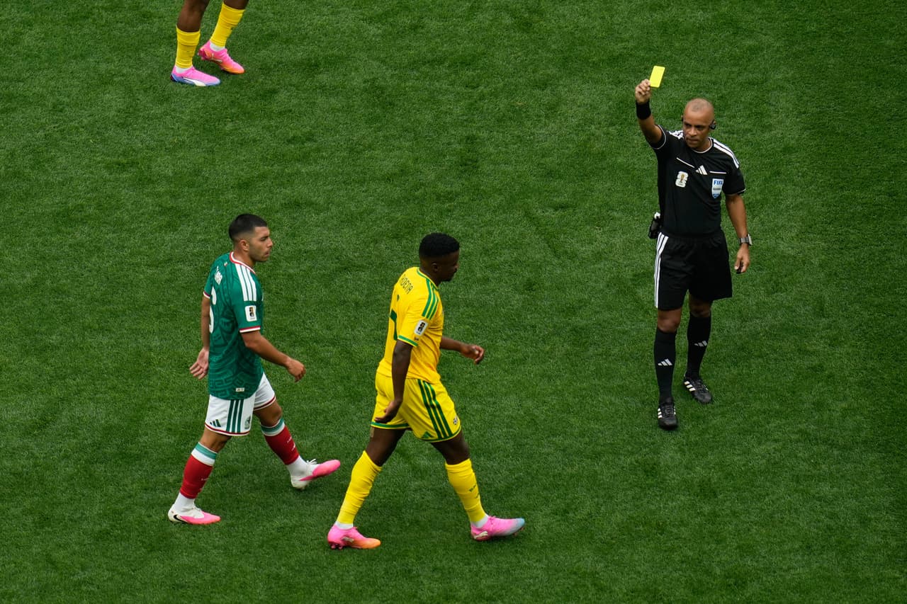 El árbitro Wilton Pereira Sampaio muestra la tarjeta amarilla al sudafricano Teboho Mokoena durante el partido de fútbol del Grupo A de la Copa del Mundo entre México y Sudáfrica en Ciudad de México.