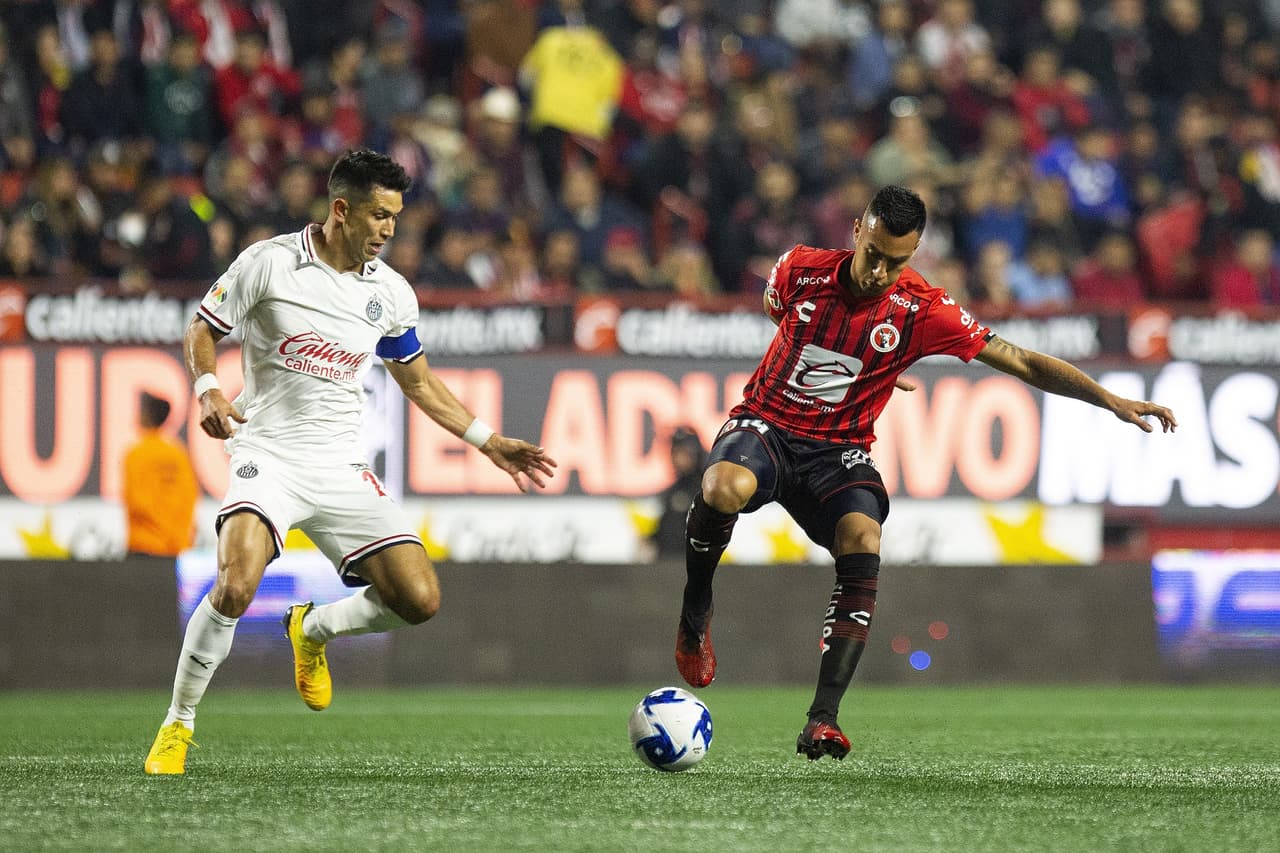 Christian Rivera trata de recortar a Jesús Molina, pero el jugador de Chivas no cae en el recorte y roba el esférico.