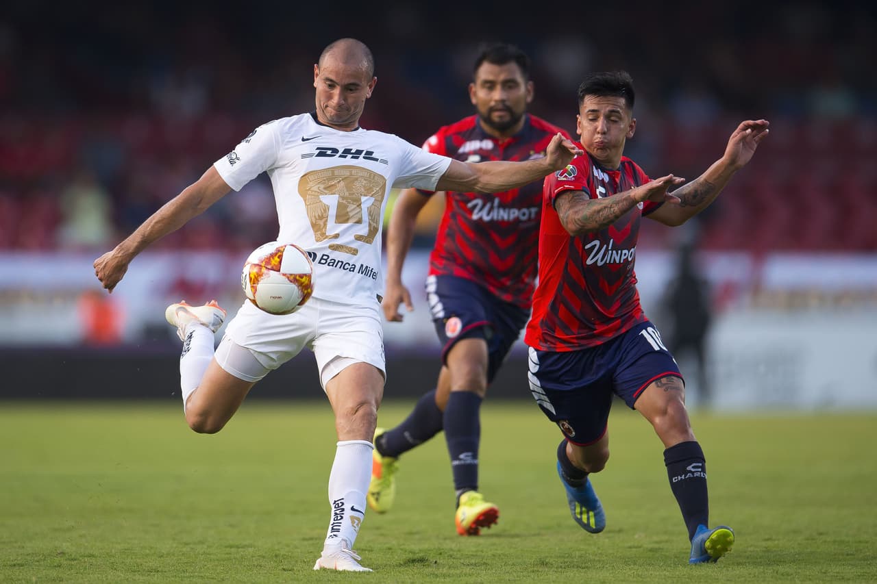 El delantero de Pumas, Carlos González (izquierda) ensaya un remate hacia el arco del Veracruz.