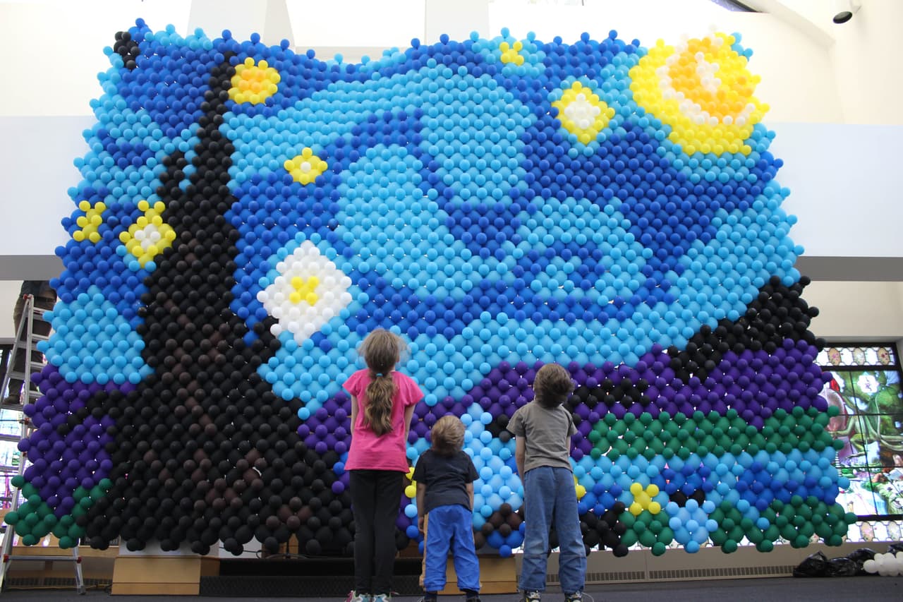 Sus tres hijos más grandes están encantados con las habilidades de su padre. ¿Quién necesita divertirse con un par de perros hechos con globos, cuando tienen un papá que puede crear murales?