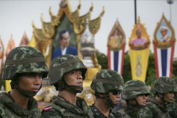Un guardia militar se para junto a un retrato de honor del rey tailandés Bhumibol Adulyadej durante una protesta contra el golpe de estado.