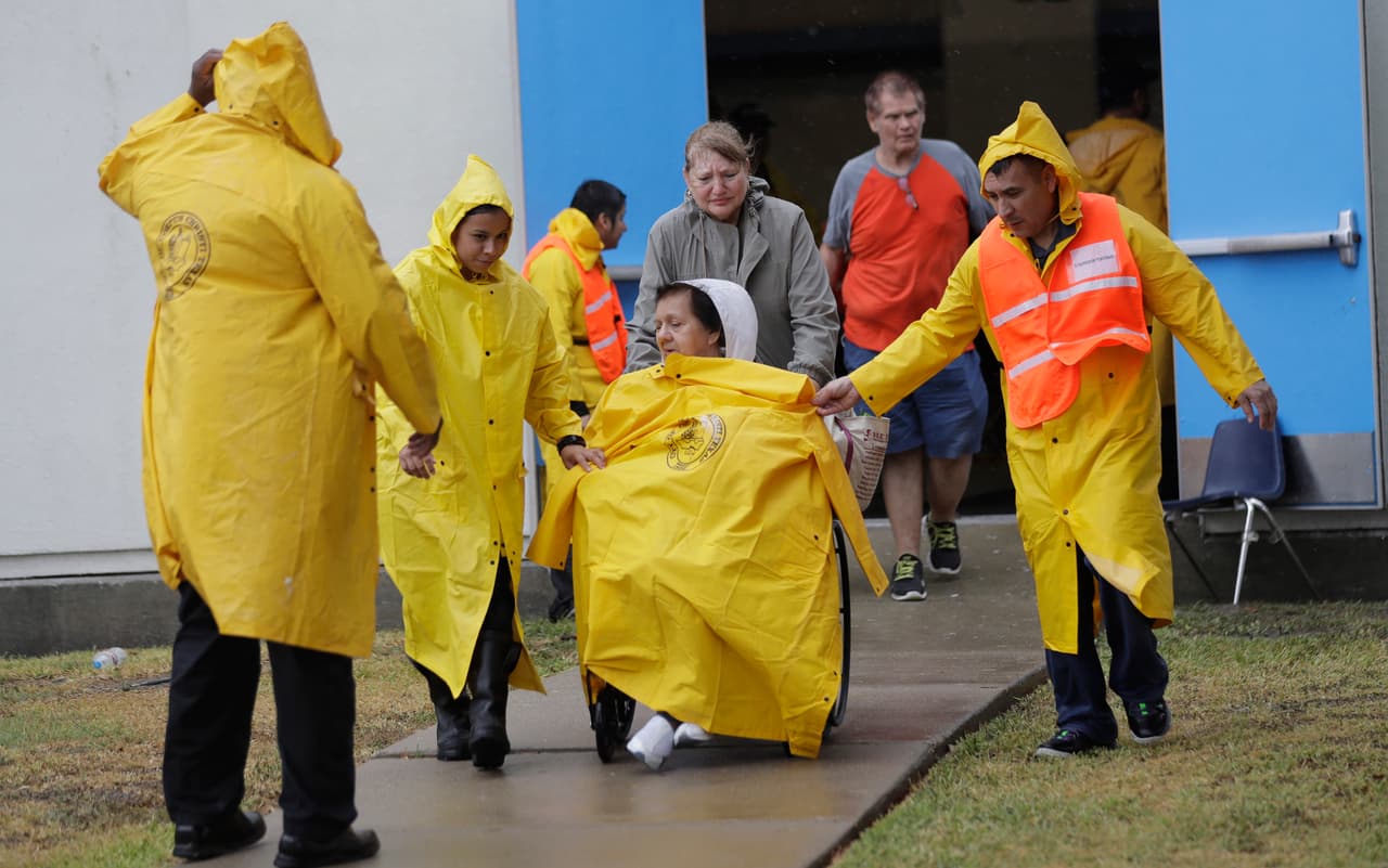 Una mujer es asistida por las autoridades para abordar un autobús en el que abandonara Corpus Christi.