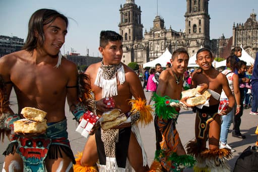 En la Ciudad de México un grupo de actores callejeros toma un descanso para comer Rosca de Reyes la mañana de este sábado en el zócalo capitalino.