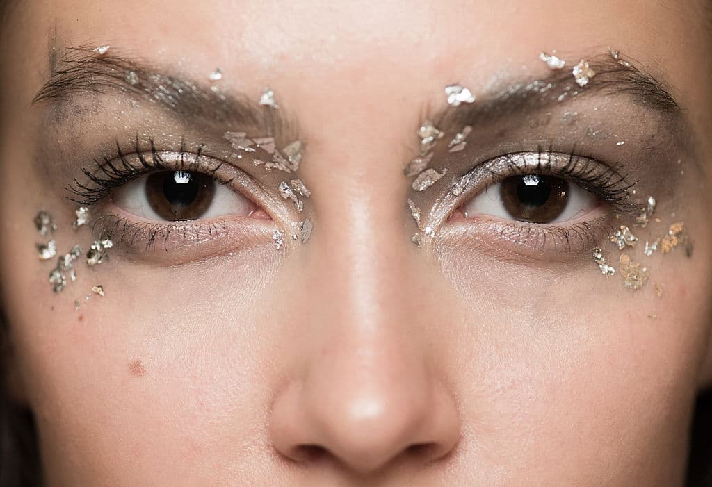 Aplicaciones de papel de oro sobre el rostro forma parte del artístico maquillaje propuesto en la presentación de 
<a href="http://www.theupcoming.co.uk/2016/09/20/iryinvigre-springsummer-2017-show-backstage-lfw/">Irynvigre</a>. Estos brillos se integran a una piel luminosa. 
<br>