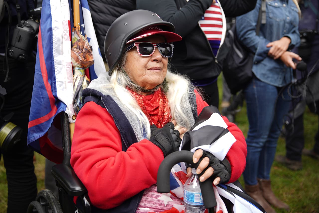 El grupo de extrema derecha Proud Boys y manifestantes liberales convergieron en el Parque Península y en otros sitios de Portland, 
<b>subiendo el nerviosismo de las autoridades por un posible enfrentamiento violento.</b> Durante la manifestación, una mujer hace el juramento a la bandera.
<br>