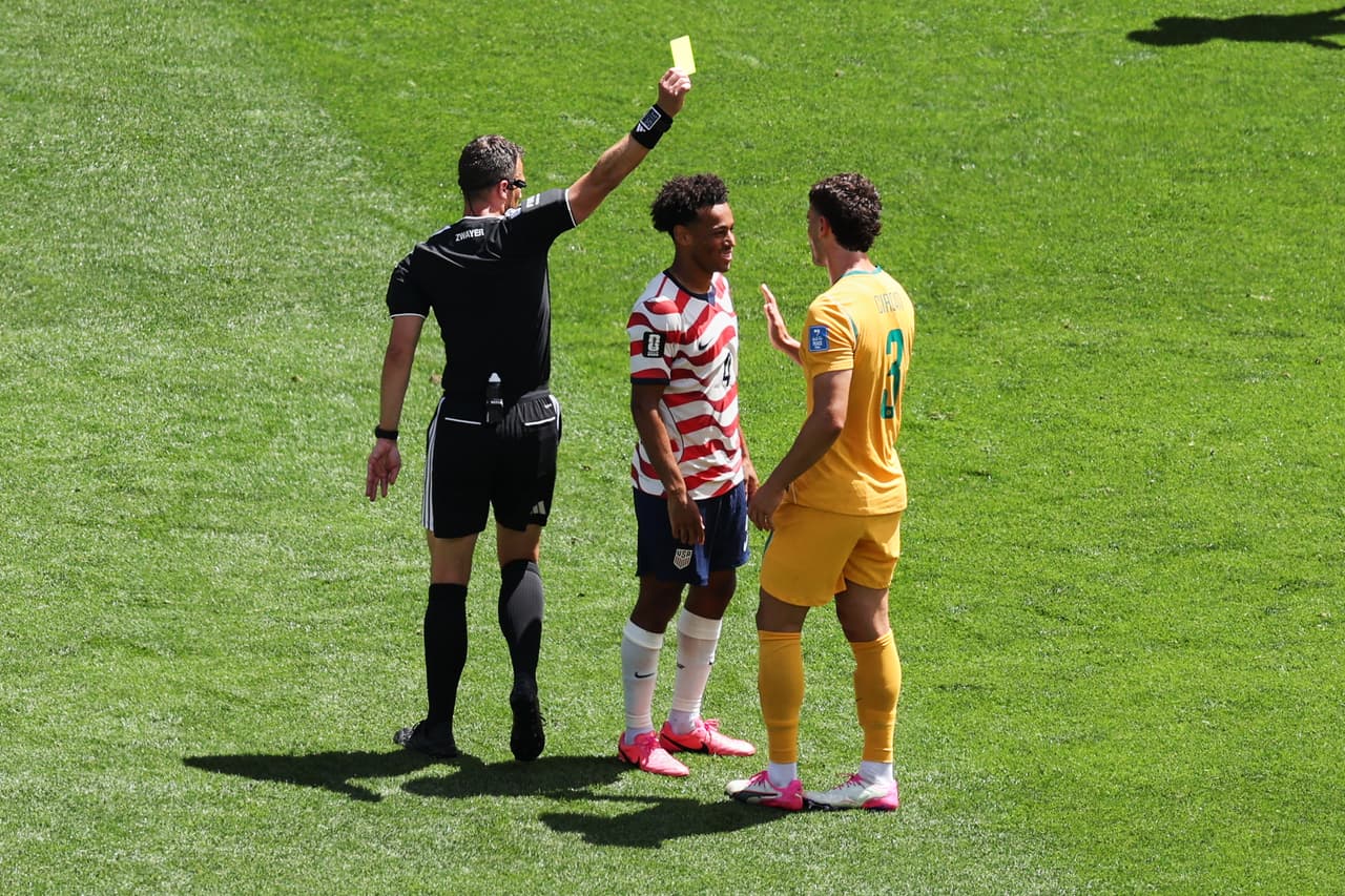 El árbitro alemán Felix Zwayer le muestra tarjeta amarilla al australiano Alessandro Circati (3), quien conversa con el estadounidense Tyler Adams (4) durante el partido de fútbol del Grupo D de la Copa Mundial entre Estados Unidos y Australia en Seattle, el viernes 19 de junio de 2026.