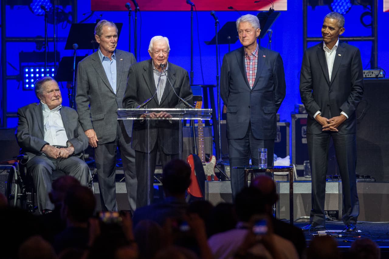 (L-R) Former US President Jimmy Carter(C) speaks along side former US Presidents George H. W. Bush, George W. Bush, Bill Clinton and Barack Obama as they attend the Hurricane Relief concert in College Station, Texas, on October 21, 2017. / AFP PHOTO / JIM CHAPIN (Photo credit should read JIM CHAPIN/AFP/Getty Images)