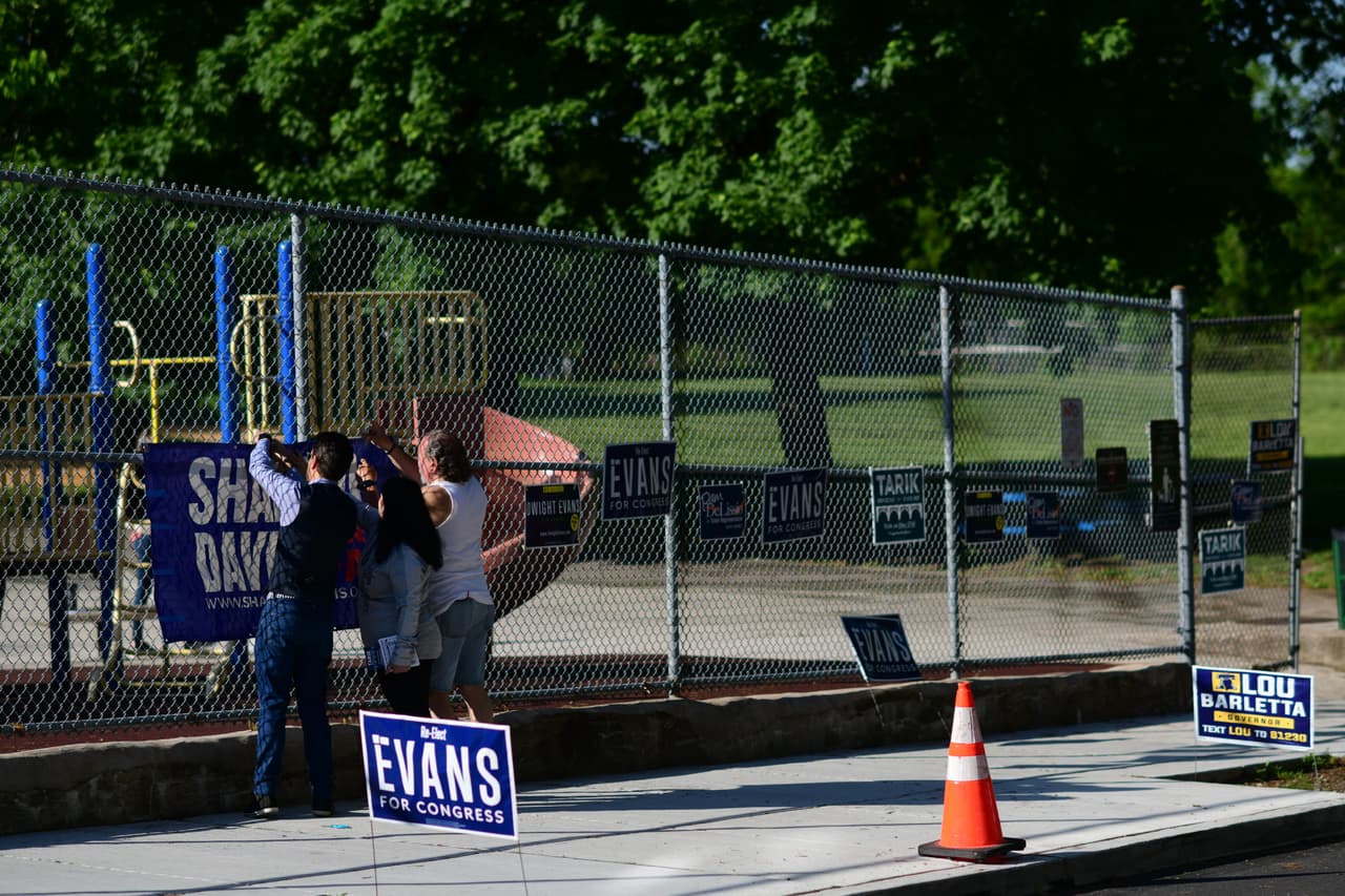 Los partidarios cuelgan una pancarta para el candidato demócrata a gobernador Josh Shapiro en el lugar de votación del Hillside Recreation Center durante las elecciones primarias de Pensilvania en Filadelfia.