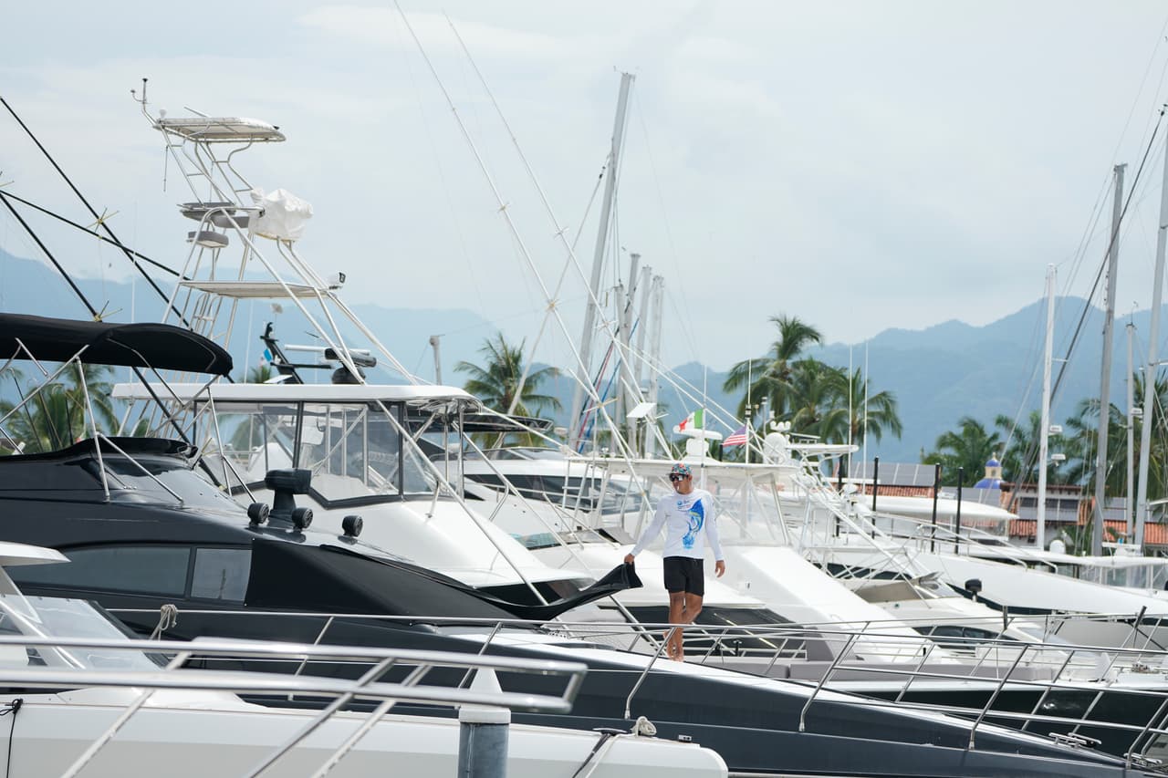 Un hombre coloca una lona en la ventana de su barco mientras el huracán Simón se acerca a Puerto Vallarta, México.