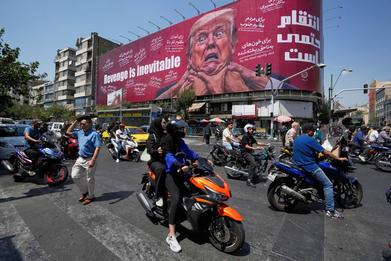 Una valla publicitaria muestra al presidente estadounidense Donald Trump con varias manos alrededor de su cuello