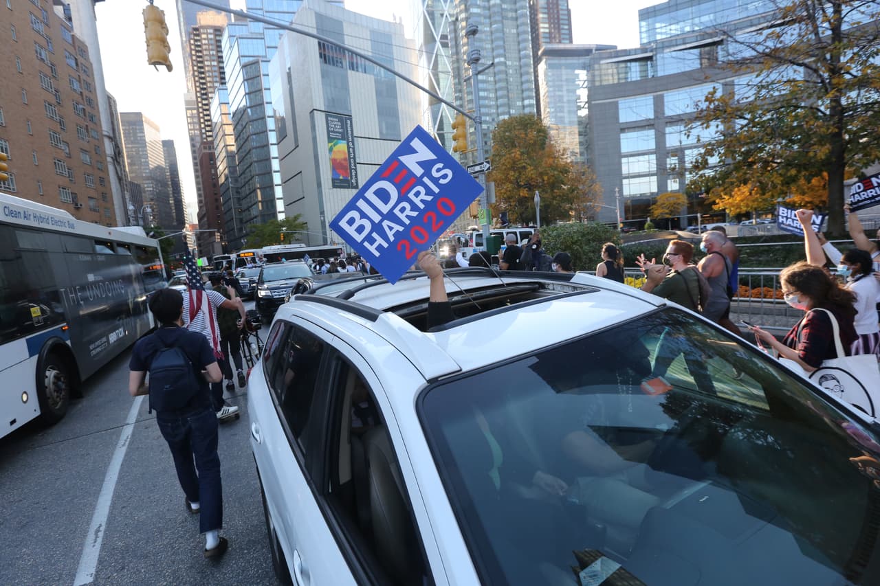 A bocinazos carros que transitan por las calles cerca de Columbus Circle se unen a la celebración de la victoria de Joe Biden y Kamala Harris