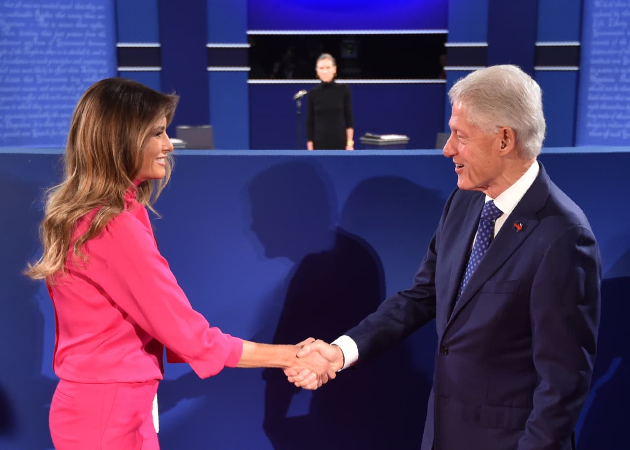 Esta foto resume muy bien esta campaña presidencial: Bill Clinton, infiel a su esposa, le da la mano a la mujer que hoy excusa a su esposo, Donald Trump. Melania, en entrevista con Anderson Cooper, dijo: "como pueden ver en el video, las cámaras no están encendidas, solo el micrófono. Y me pregunto si ellos sabían si el micrófono estaba encendido [...] a veces digo que tengo dos chicos en casa: mi hijo y mi esposo". The New York Times afirma que Melania "imita los mismos argumentos de conspiración que usó Hillary para defender a Bill".