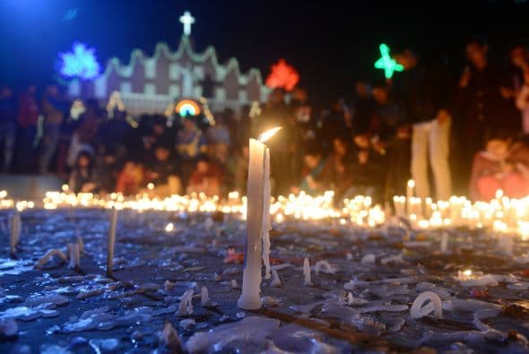 Cristianos encienden velas en un servicio de día de Navidad fuera de la iglesia de Santa María en Siliguri.