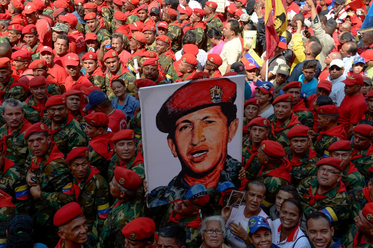 Un grupo de milicianos sostiene un retrato del "comandante" durante el vigésimo cuarto aniversario de la intentona golpista liderada por Hugo Chávez.