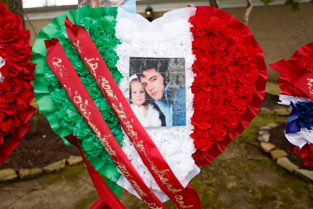 Afuera de la mansión Graceland, otro de los fanáticos llevó un arreglo de glores y al centro puso una fotografía de Lisa Marie presley cuando era niña al lado de su papá, Elvis Presley.