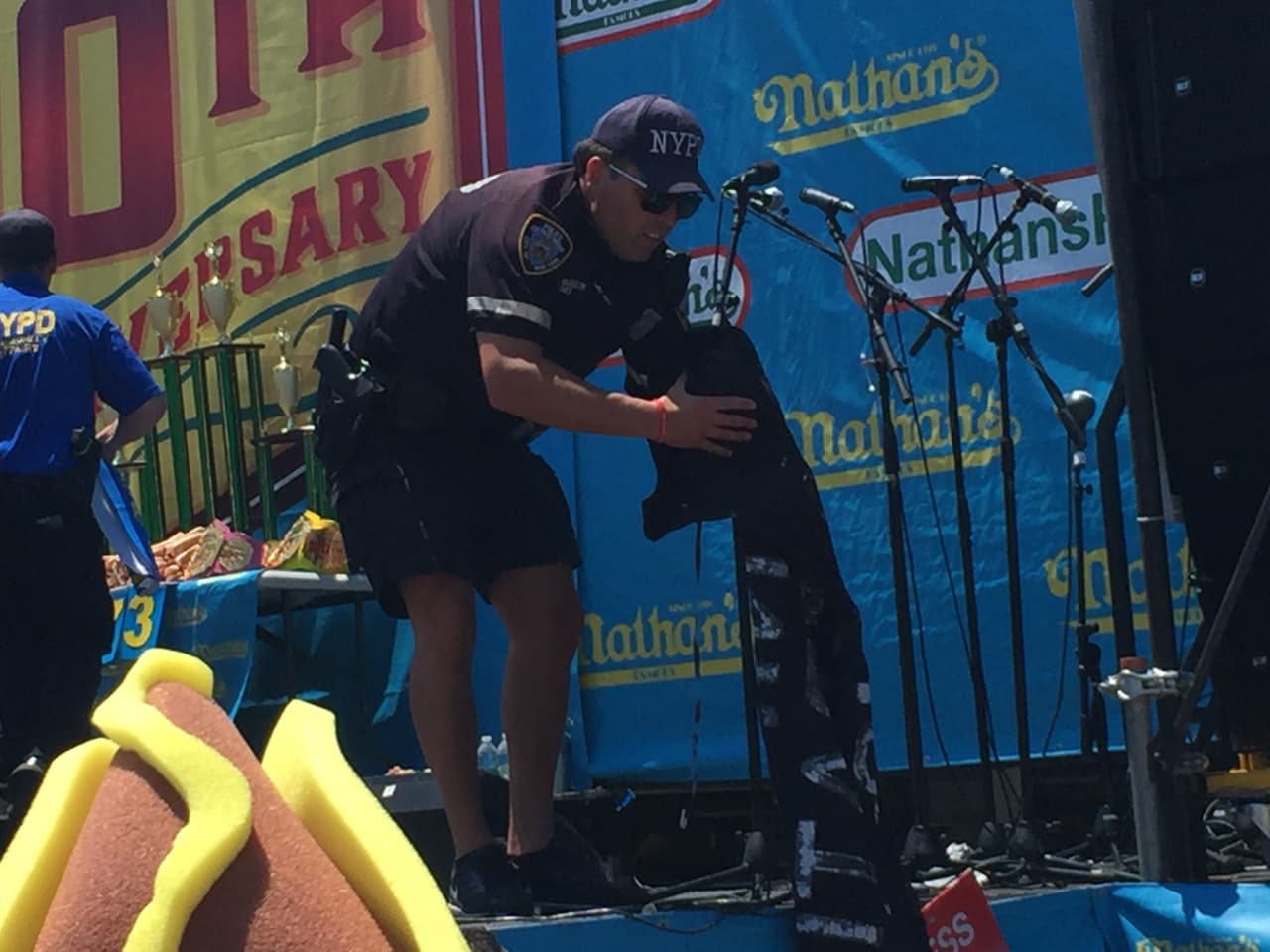 Un oficial recoge una pancarta que los manifestantes dejaron en el escenario.