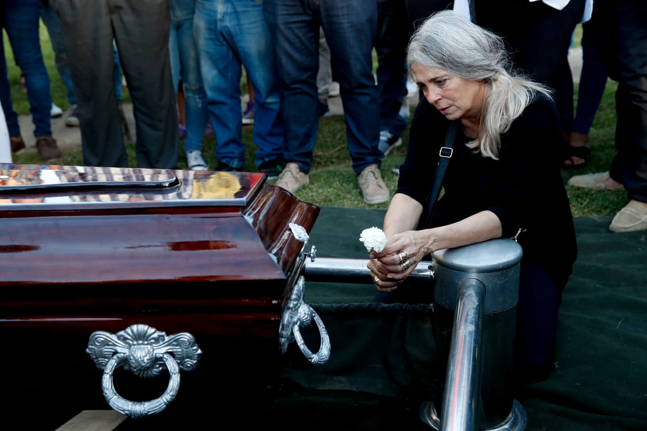 Patricia Nasutti, madre de Ursula Bahillo, de 18 años, se arrodilla junto al ataúd que contiene los restos de su hija en un cementerio durante un funeral en Rojas, en febrero 2021.