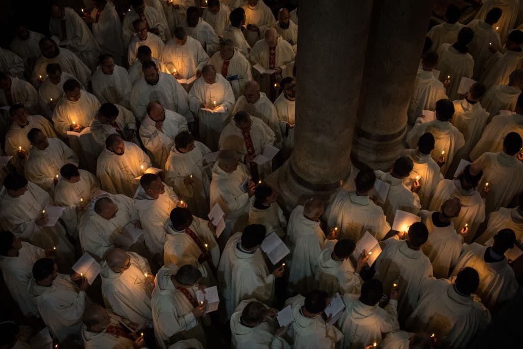 Decenas de religiosos, con velas encendidas, durante la procesión de Pascua en Jerusalén.