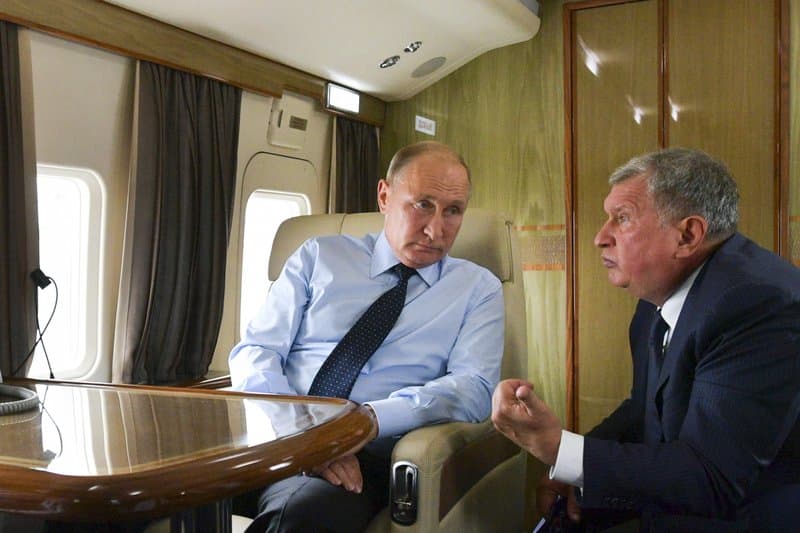 Russian President Vladimir Putin, on the left, listens to Russian Rosneft CEO Igor Sechin during his flight to visit a coal mine in Russia, August 27, 2018.