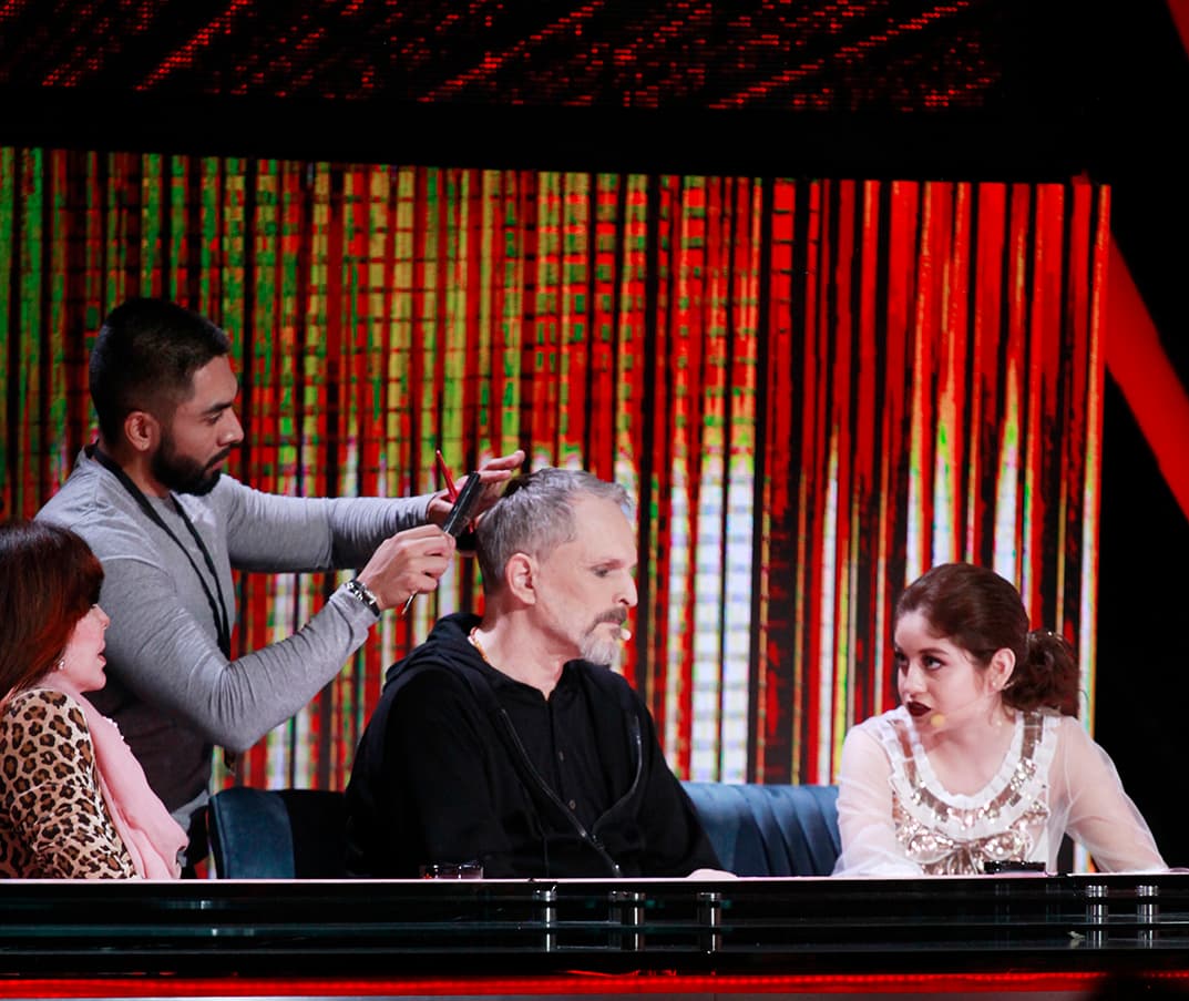 Aquí vemos cómo Miguel Bosé es peinado mientras Verónica y Karol intercambian puntos de vista.