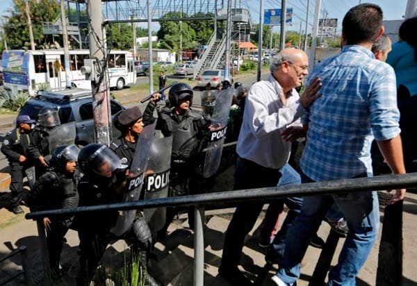 Nicaraguan riot police push back journalists, including Carlos Fernando Chamorro, on Saturday in Managua.