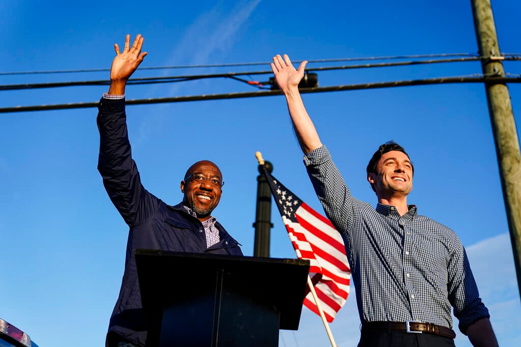 Raphael Warnock, izquierda, y Jon Ossoff, candidatos demócrata al Senado federal, saludan a simpatizantes durante un mitin en Marietta, Georgia, el domingo 15 de noviembre de 2020.