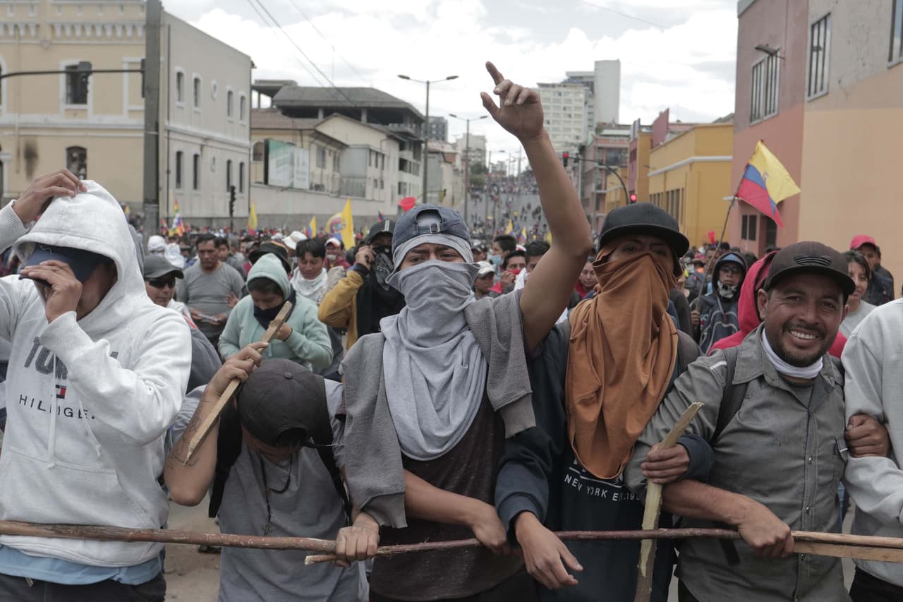 Manifestantes con sus rostros cubiertos cantan consignas cerca del Palacio Presidencial de Carondelet durante las protestas contra el fin de los subsidios a la gasolina y el diesel anunciados por el gobierno del presidente Lenin Moreno este miércoles. Camioneros y taxistas comenzaron a bloquear las carreteras cercanas al país, lo que amenaza el acceso a la capital Quito, ubicada en un valle de montaña a 2.800 metros sobre el nivel del mar.