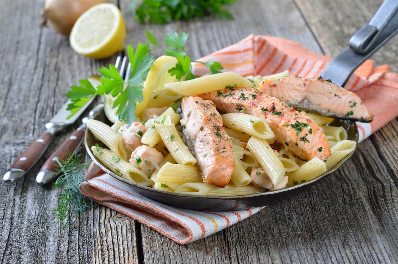 Pasta con salmón. Una pasta con pescado es deliciosa puedes experimentar con esta de salmón que lleva 6 cucharadas de mantequilla, 1/2 cebolla picada finamente, 2 cucharadas de harina, ajo en polvo, 2 tazas de leche descremada, 1 taza de guisantes, 1/2 taza de queso rallado, 1/2 taza de champiñones, 250 gr de salmón ahumado picado y 450 gr de pasta.