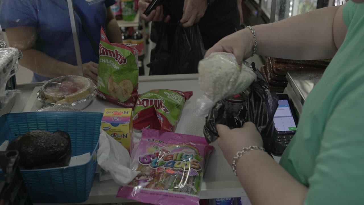 Josué y Xiomara pagando su compra. Ambos tienen casi 20 años viviendo en Estados Unidos. Él es originario de México, ella de El Salvador. Sus dos hijas nacieron en este país.