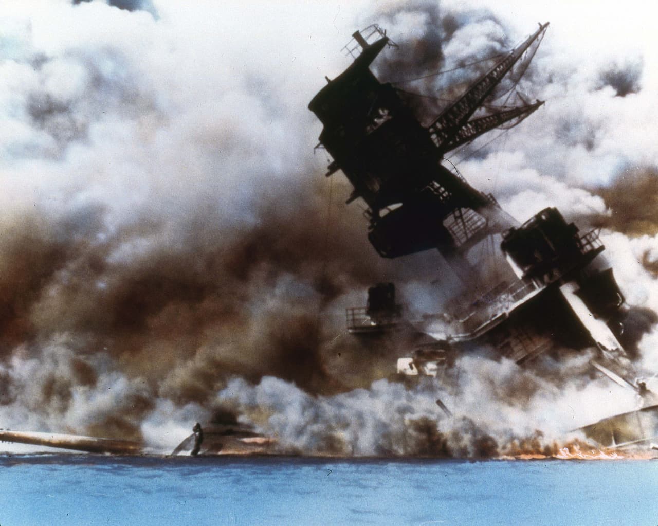 El acorazado USS Arizona en llamas mientras se hundía en la bahía de Pearl Harbor, el 7 de diciembre de 1941.
<br>
<br>En la avanzada japonesa resultaron dañados los ocho acorazados estadounidenses atracados en el puerto y cuatro de ellos se hundieron.