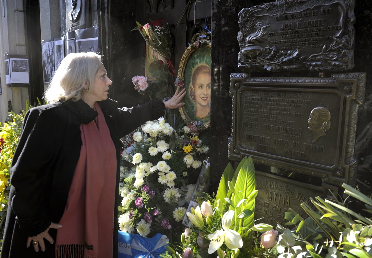 Una mujer toca la foto de Evita en su tumba. Eva Perón, incluso fuera de Argentina, ha sido ampliamente reconocida en decenas de libros, ensayos, obras de teatro, musicales, películas y ahora también una serie de televisión.
