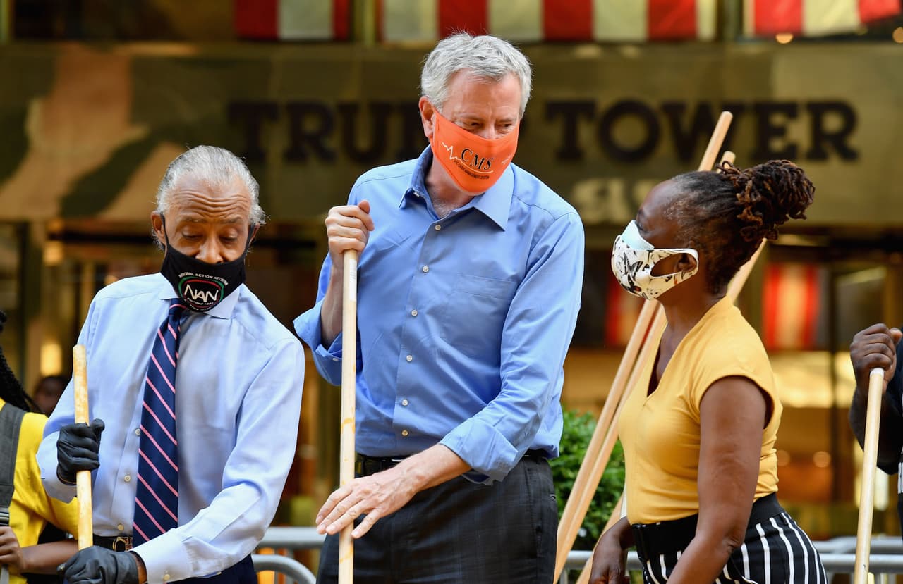En la pintada frente a la sede de la organización Trump el alcalde De Blasio estuvo flanqueado por su esposa, Chirlane McCray, y el reverendo y activista Al Sharpton.