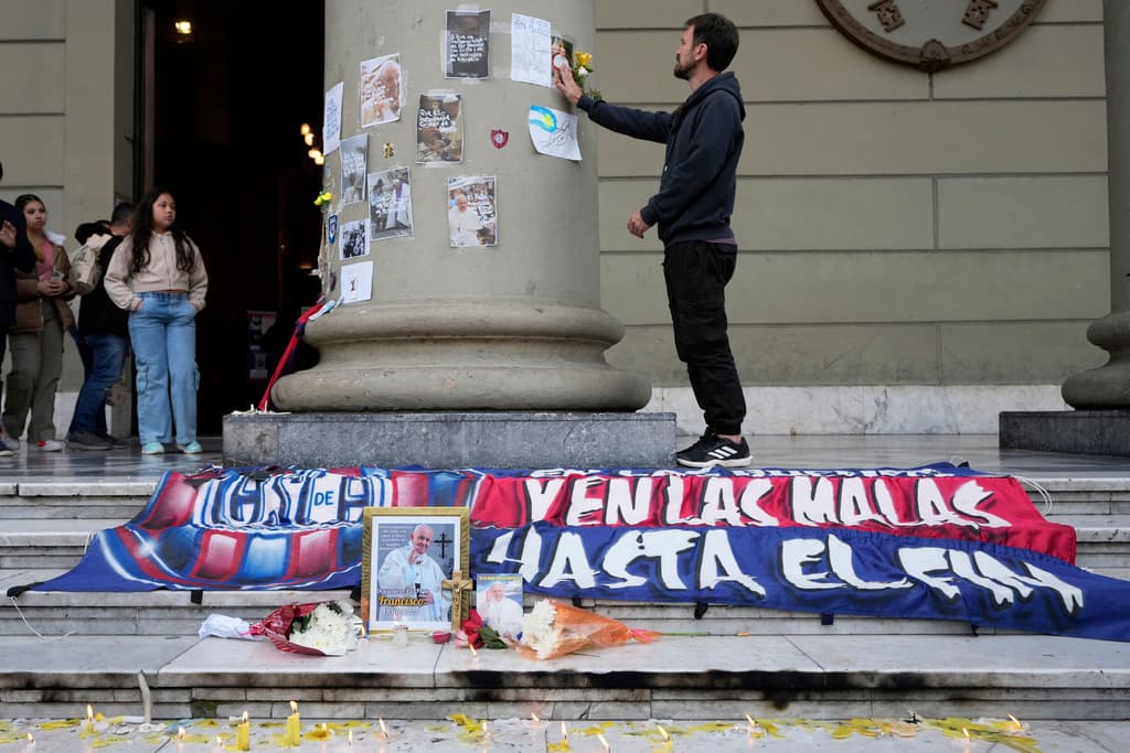 <h3 class="cms-H3-H3">"En las buenas y en las malas, hasta el fin"</h3>
<br>
<br>Velas rodean un retrato del difunto Papa Francisco, envuelto en una bandera del club de fútbol San Lorenzo, en la Catedral de Buenos Aires, Argentina.
<br>