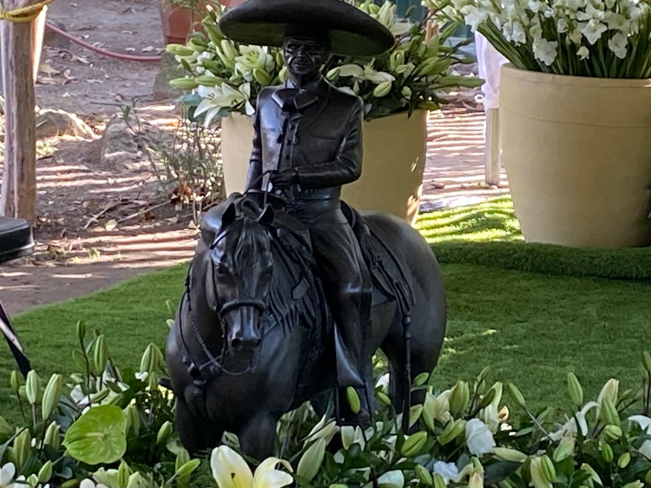 En la imagen se pueden observar decenas de ramos de flores y una estatua del 'Charro de Huentitán' en la cabecera de la tumba.