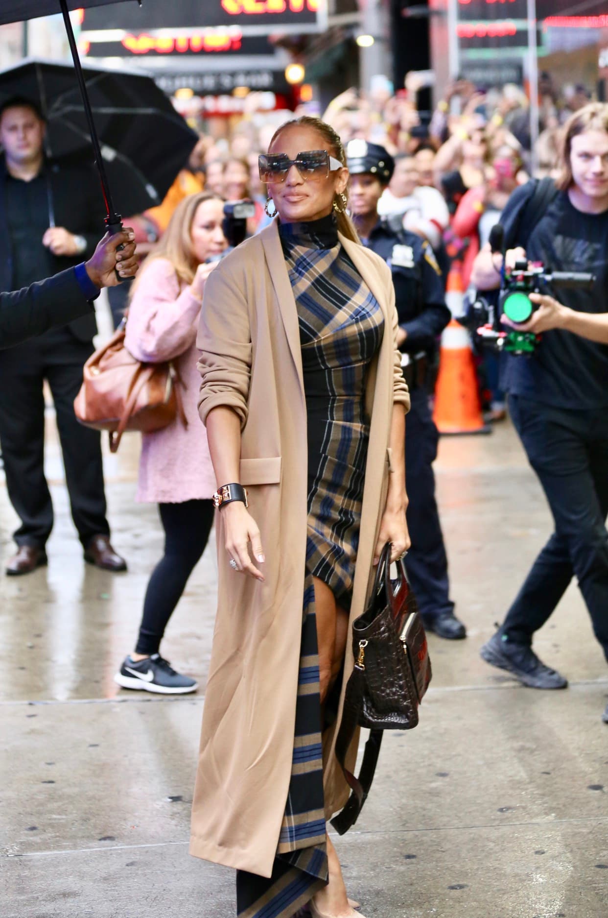 <b>Look 9</b>
<br>Por la mañana, para llegar a los estudios de 'Good Morning America' en septiembre 10, Jennifer López lució un 
<b><a href="https://www.modaoperandi.com/monse-pf19/plaid-cowl-neck-shirt-dress?color=navy&size=US+2?country=US&ranMID=37385&ranEAID=3096943&ranSiteID=.2nGiS3mv0Y-FHeV8HW3hNQF6C2SwQFlHA&mid=37385&utm_source=rakuten_affiliate&utm_medium=ShopStyle++Collective&utm_campaign=conversion&utm_term=&siteID=.2nGiS3mv0Y-FHeV8HW3hNQF6C2SwQFlHA" target="_blank">vestido asimétrico</a></b> de Monse estampado en príncipe de gales ($1,190), zapatos
<b> <a href="https://us.jimmychoo.com/en/women/shoes/anouk/nude-suede-pointy-toe-pumps-ANOUKSUE120008.html?utm_term=J84DHJLQkR4&cm_mmc=LinkShareUS-_-Affiliate-_-J84DHJLQkR4-_-10&utm_campaign=USNetwork&utm_medium=LinkShare&ranSiteID=J84DHJLQkR4-PopLp0_dNoCdWADqnNGwaQ&ranMID=37499&ranEAID=J84DHJLQkR4&utm_source=Affiliate&utm_content=10" target="_blank">Jimmy Cho</a></b>
<a href="https://us.jimmychoo.com/en/women/shoes/anouk/nude-suede-pointy-toe-pumps-ANOUKSUE120008.html?utm_term=J84DHJLQkR4&cm_mmc=LinkShareUS-_-Affiliate-_-J84DHJLQkR4-_-10&utm_campaign=USNetwork&utm_medium=LinkShare&ranSiteID=J84DHJLQkR4-PopLp0_dNoCdWADqnNGwaQ&ranMID=37499&ranEAID=J84DHJLQkR4&utm_source=Affiliate&utm_content=10" target="_blank">o</a> ($650), el brazalete
<b> <a href="https://es.vestiairecollective.com/mujer-joyas/pulseras/hermes/pulseras-collier-de-chien-hermes-de-cuero-gris-5953894.shtml" target="_blank">Collier de Chien</a></b> de Hermés y un
<b> <a href="https://www.luisaviaroma.com/en-us/p/max-mara/women/70I-AIO002?ColorId=MDMw0&lvrid=_p_dLCG_gw&AID=10617612&PID=7900573&SID=4190191952&utm_source=CommissionJunction&utm_medium=affiliation&utm_content=7900573&utm_campaign=4609662&CJEVENT=f5dade01d59c11e983bf042a0a240613" target="_blank">bolso</a></b> de Max Mara. Se cubrió con un abrigo beige largo al tobillo.